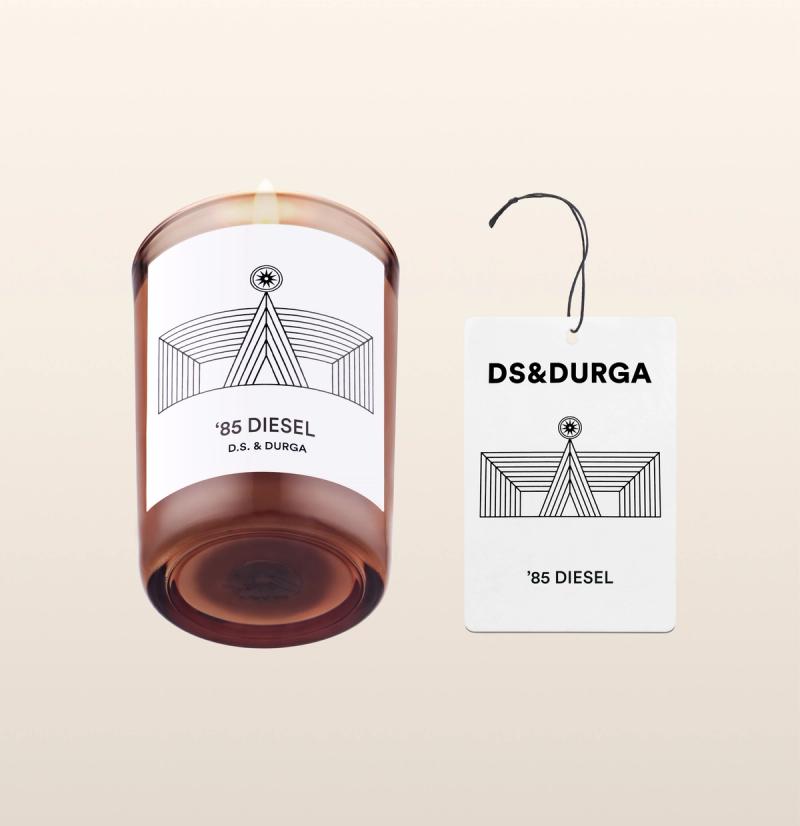 An elegant, lit scented candle by d.s. & durga with '85 diesel fragrance, accompanied by a matching auto fragrance. 