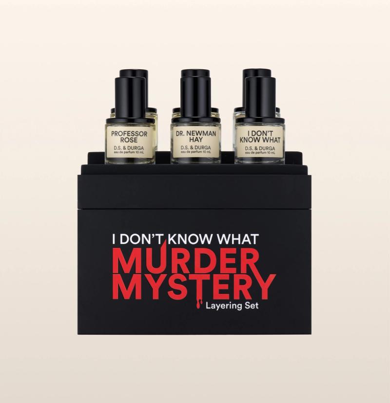 A perfume layering set in sleek black packaging with red and white text that reads "I DON'T KNOW WHAT MURDER MYSTERY." The set includes three bottles labeled "PROFESSOR ROSE," "DR. NEWMAN HAY" and "I DON'T KNOW WHAT.