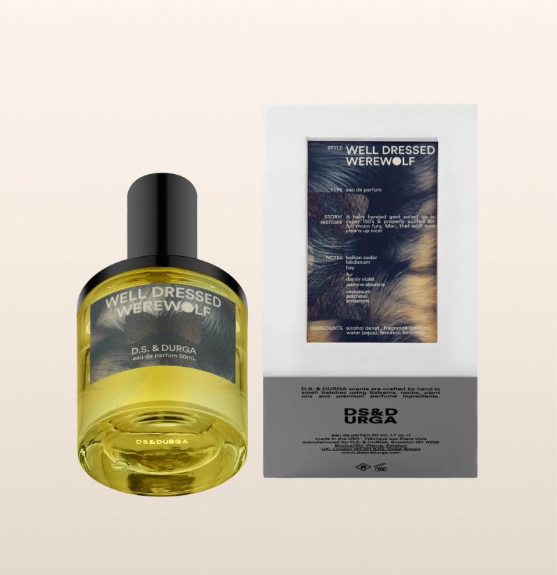A bottle and box of D.S. & Durga "Well Dressed Werewolf" perfume. The bottle is round with yellow liquid and a black cap; the box displays product details and an image resembling fur.