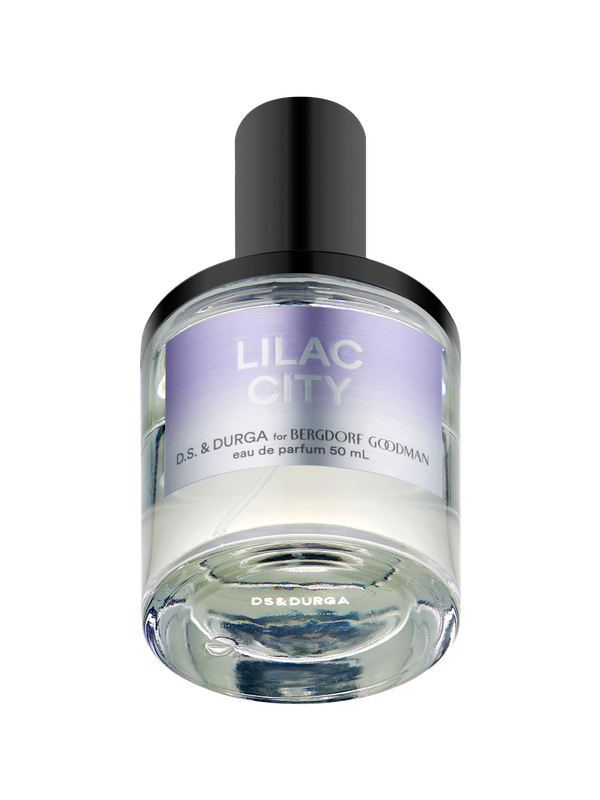 A bottle of perfume labeled "Lilac City" by D.S. & Durga for Bergdorf Goodman. The bottle is clear with a black cap and has a light purple label. The text on the label includes "eau de parfum 50 mL.