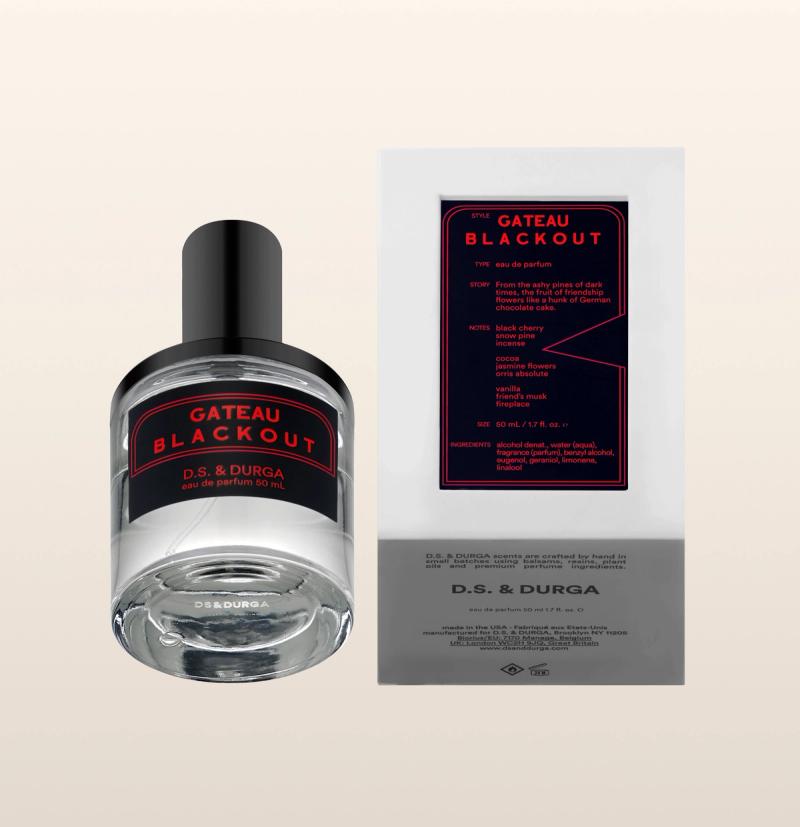 A bottle of "gateau blackout" perfume by d.s. & durga next to its packaging. the clear glass bottle features a black and red label, and the packaging has a detailed red and black design.