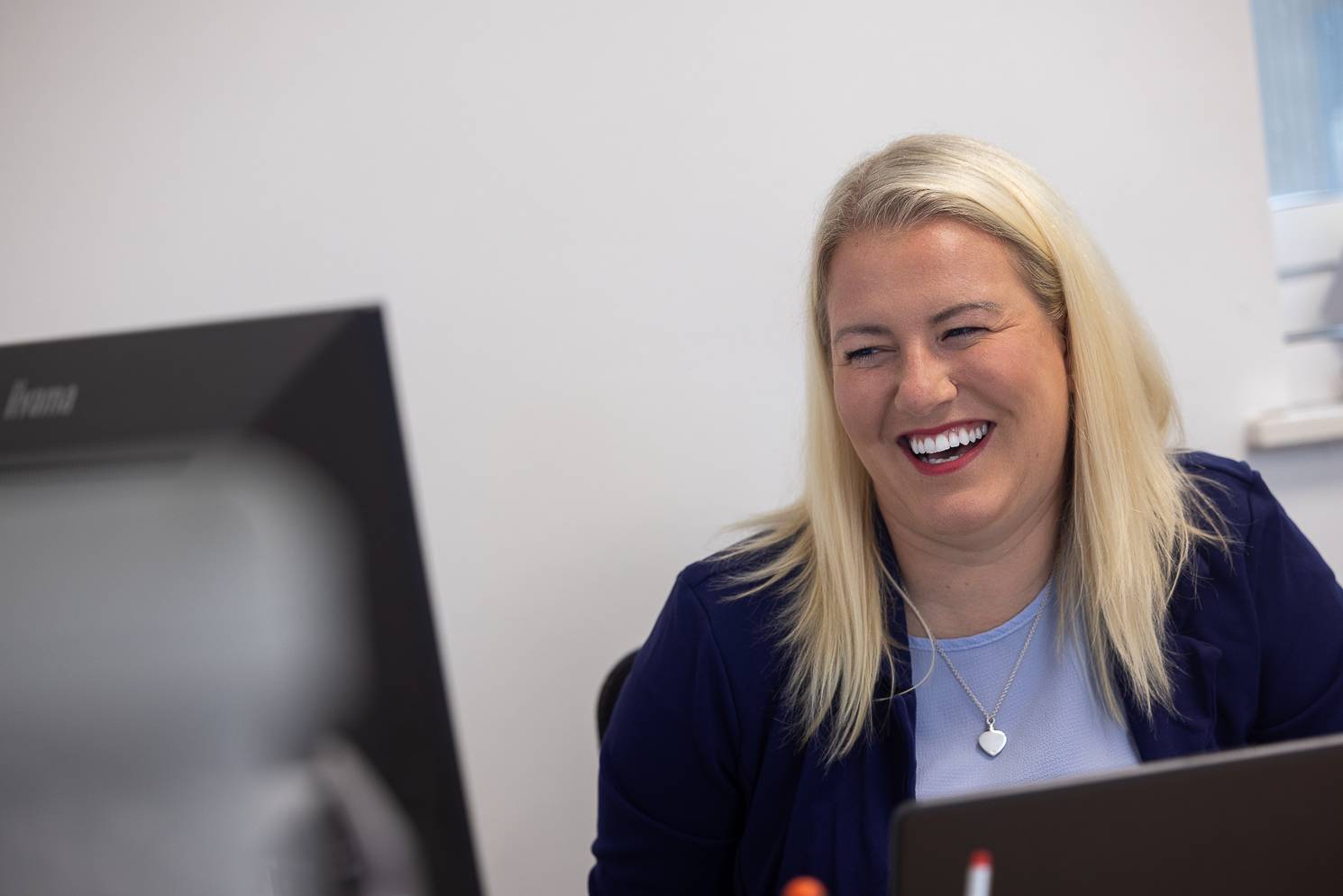 Practice manager Sophie Burrows laughs while speaking to a patient who isn't in the image