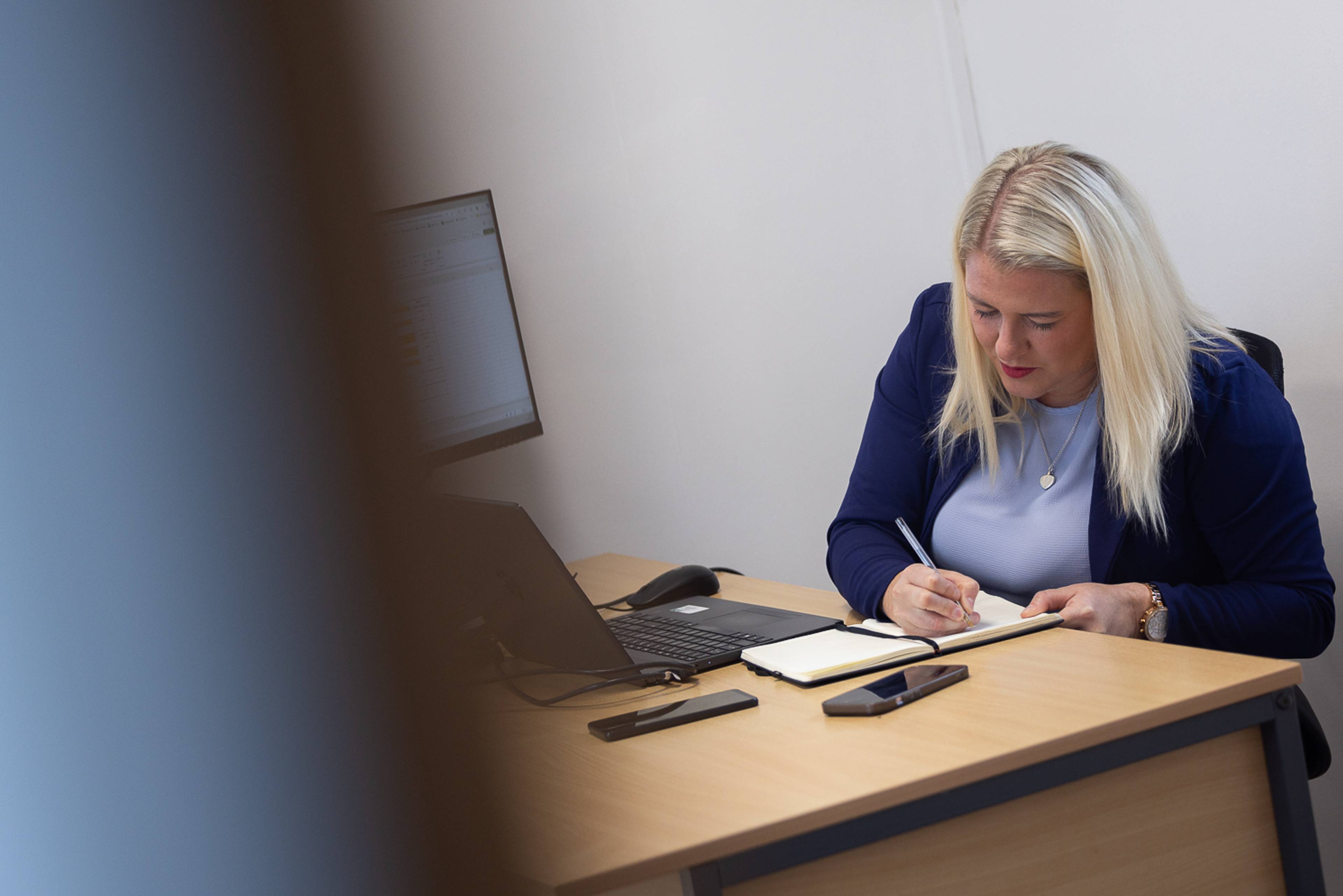Our practice manager working at a computer in the Plymouth City Centre Dental Practice reception area
