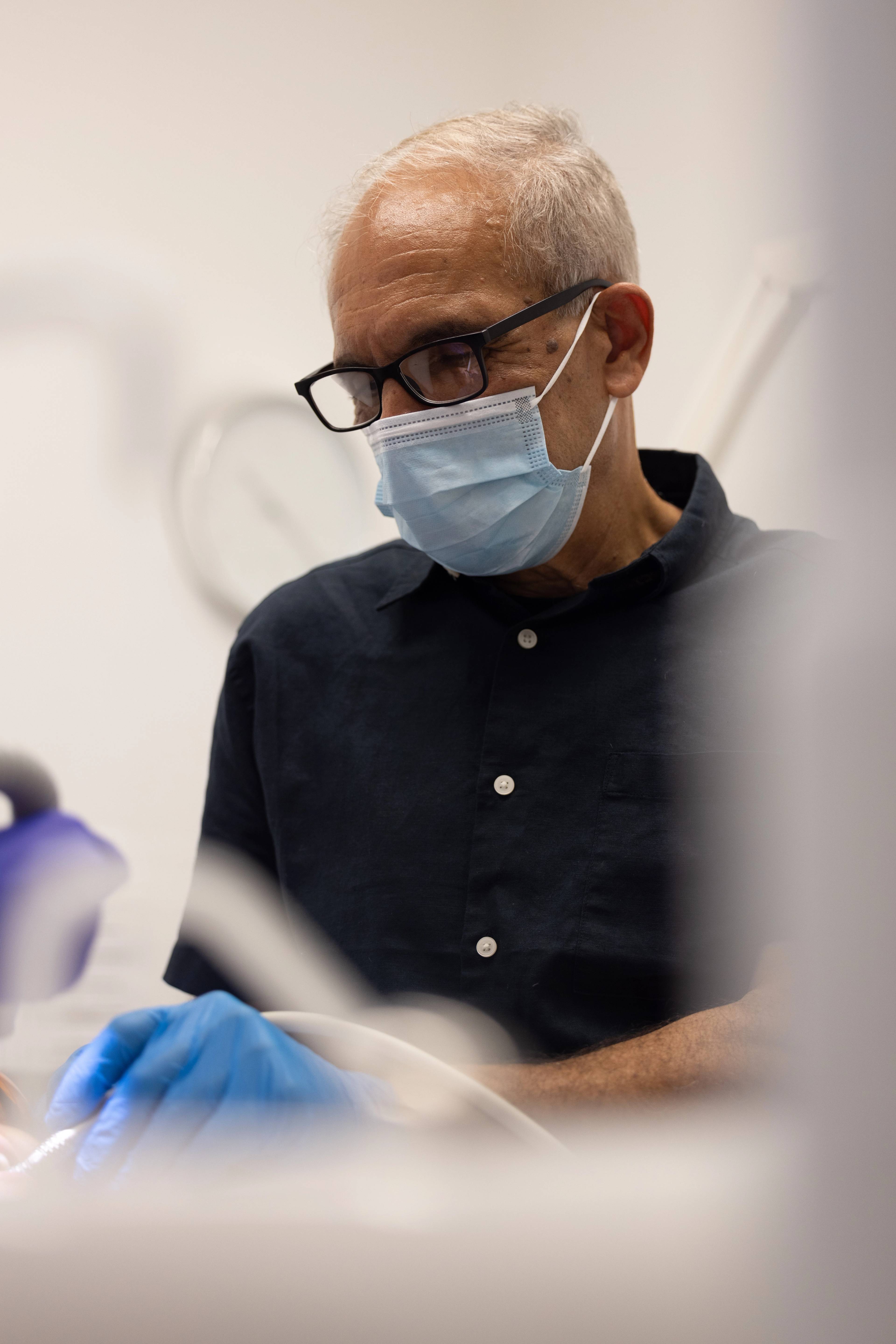 Dentist Shahriar Majlessi working on a patient in a treatment room