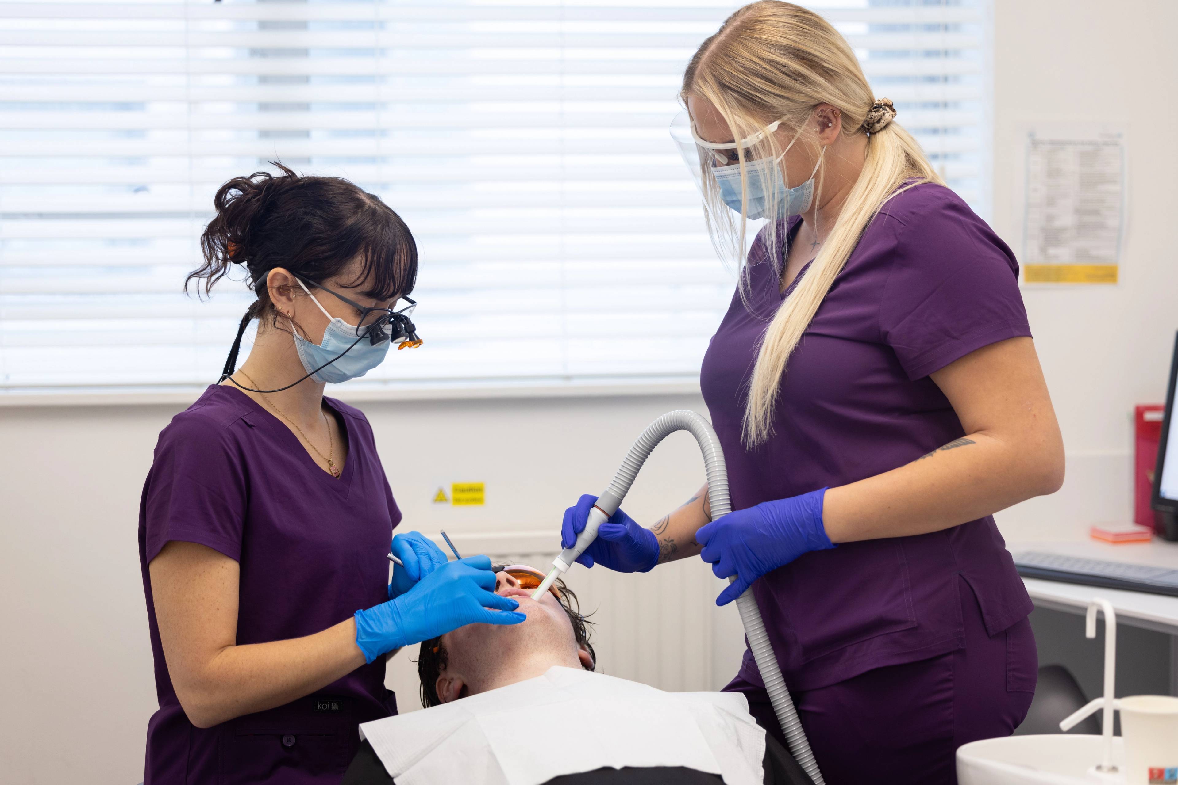 Dental hygienists Lucy Steward and Amy Thorne clean a patient's teeth