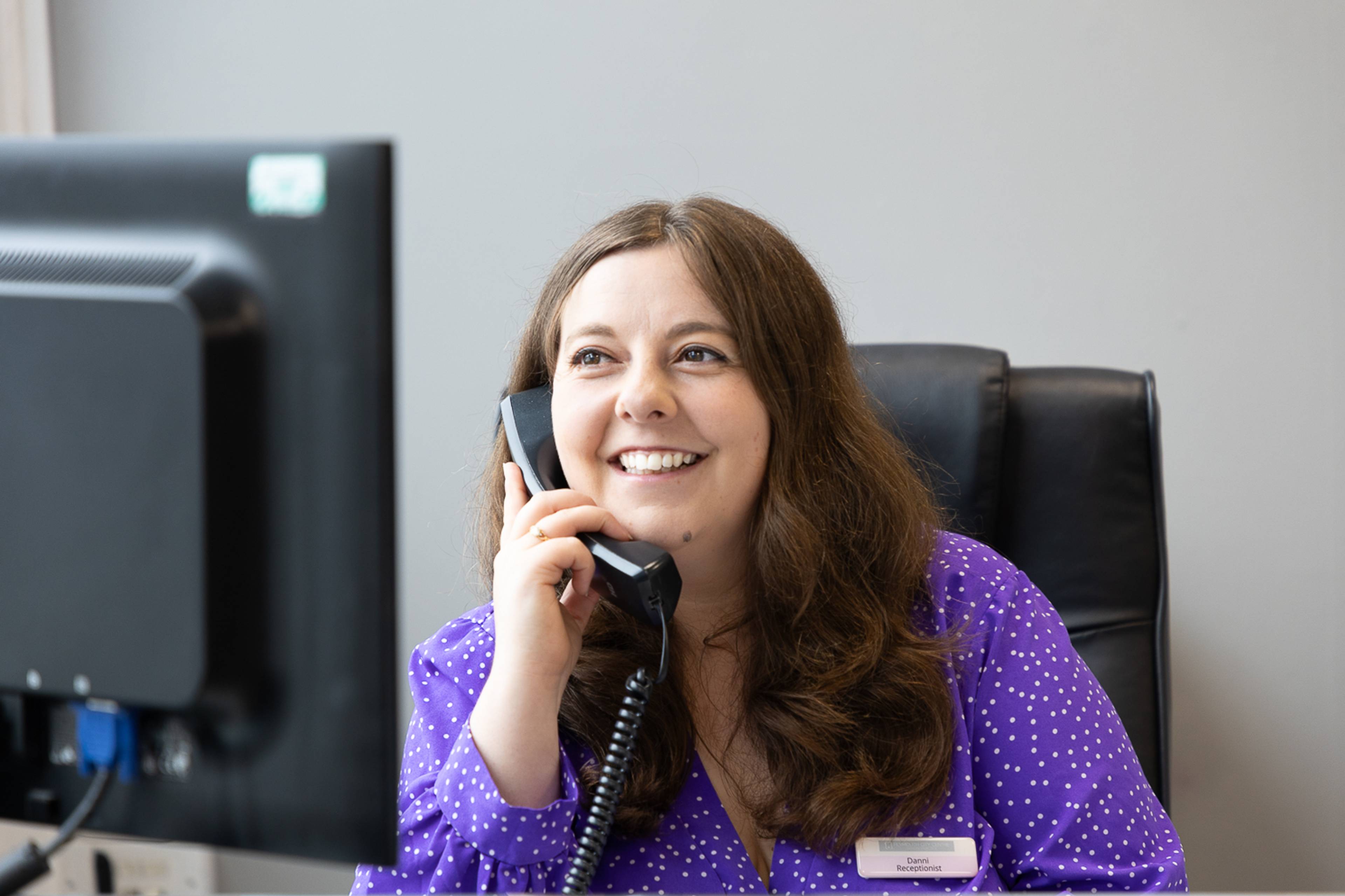 Receptionist Danni smiling while speaking with a patient at the Plymouth City Centre Dental Practice clinic