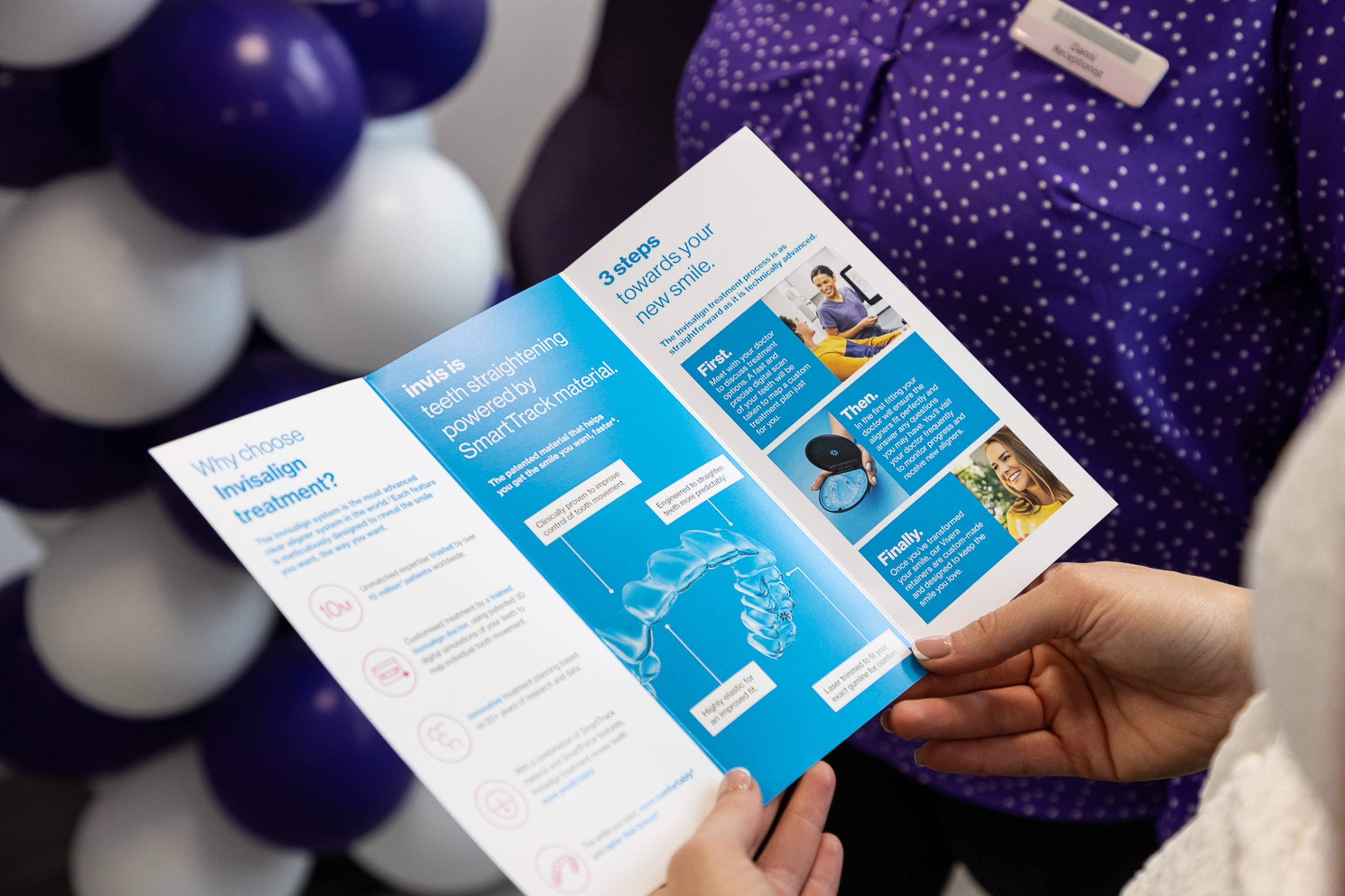 A patient holding an Invisalign leaflet