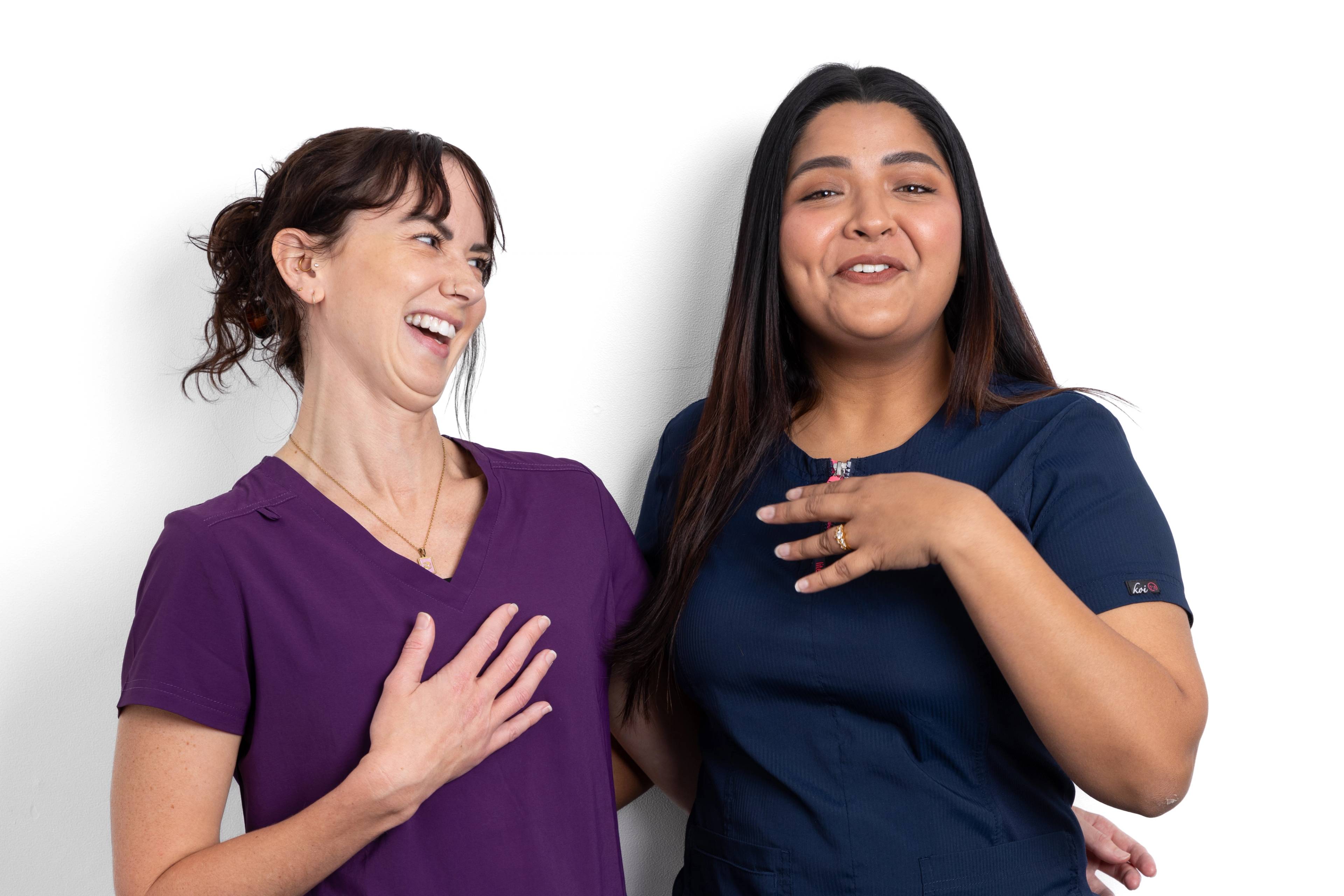 Dental therapists Lucy Steward and Gayathiri Devadas laugh warmly while looking at the camera