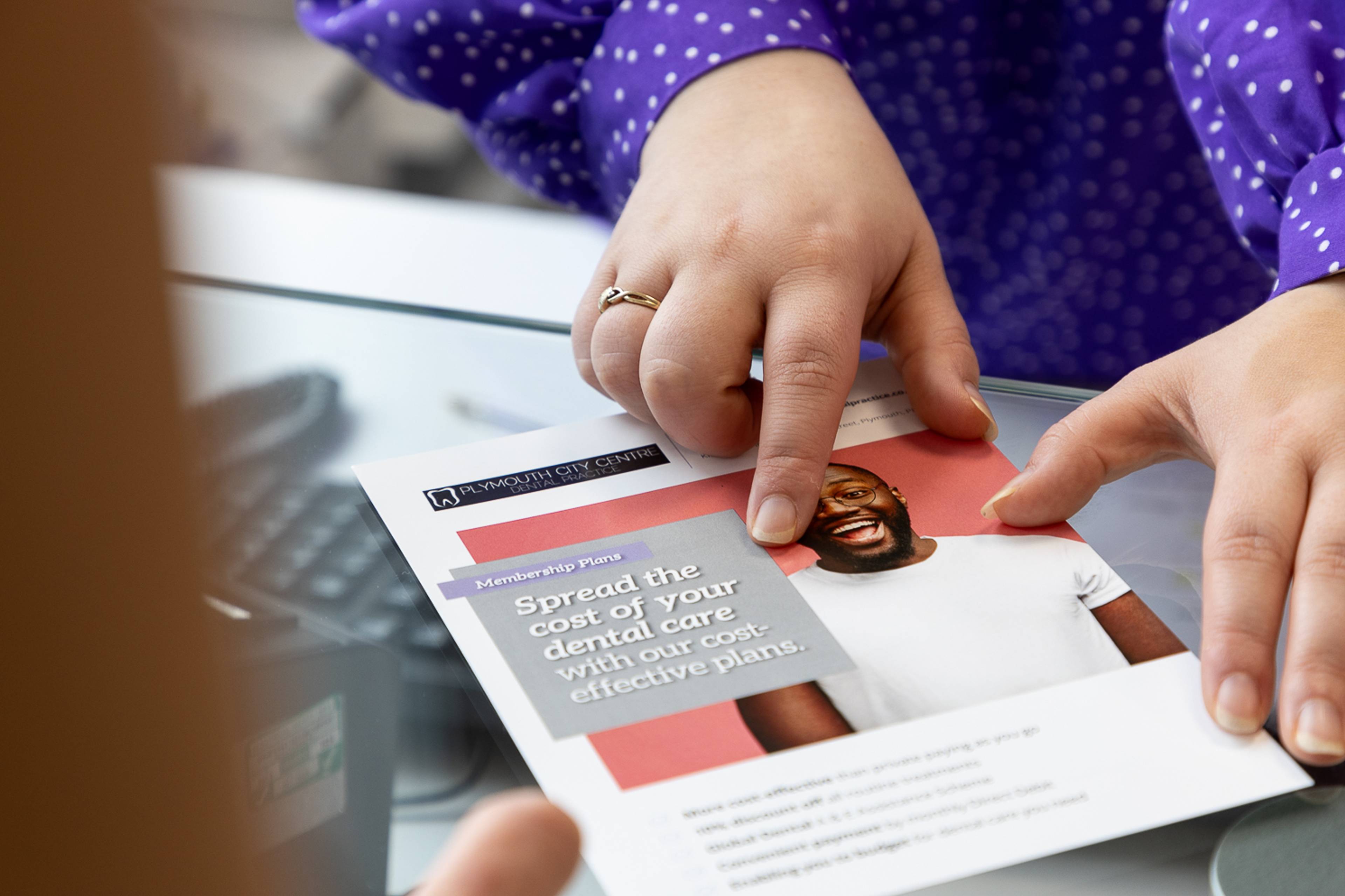 Receptionist Danni Brown showing a financing leaflet to one of our patients