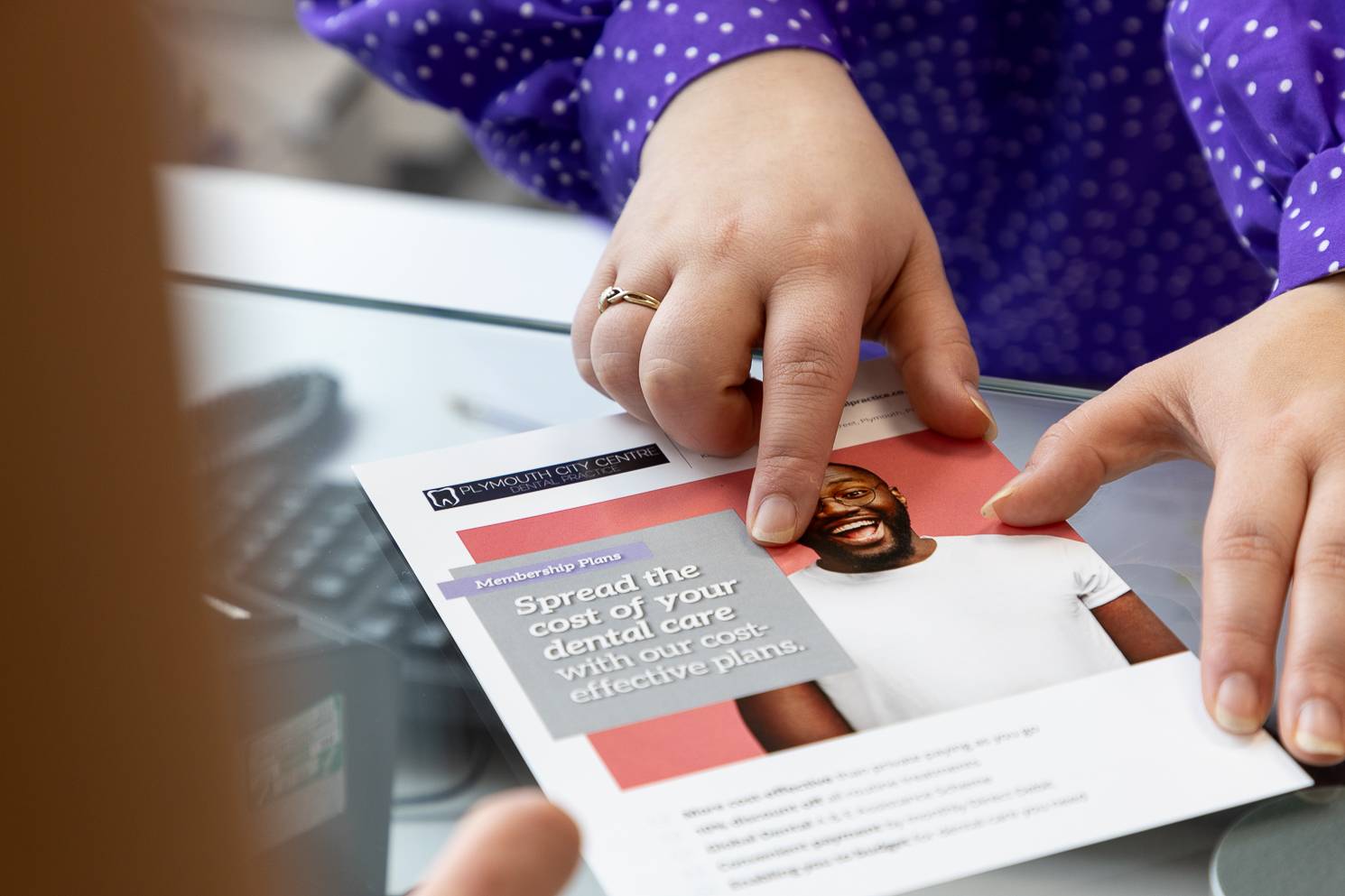 Receptionist Danni Brown showing a financing leaflet to one of our patients