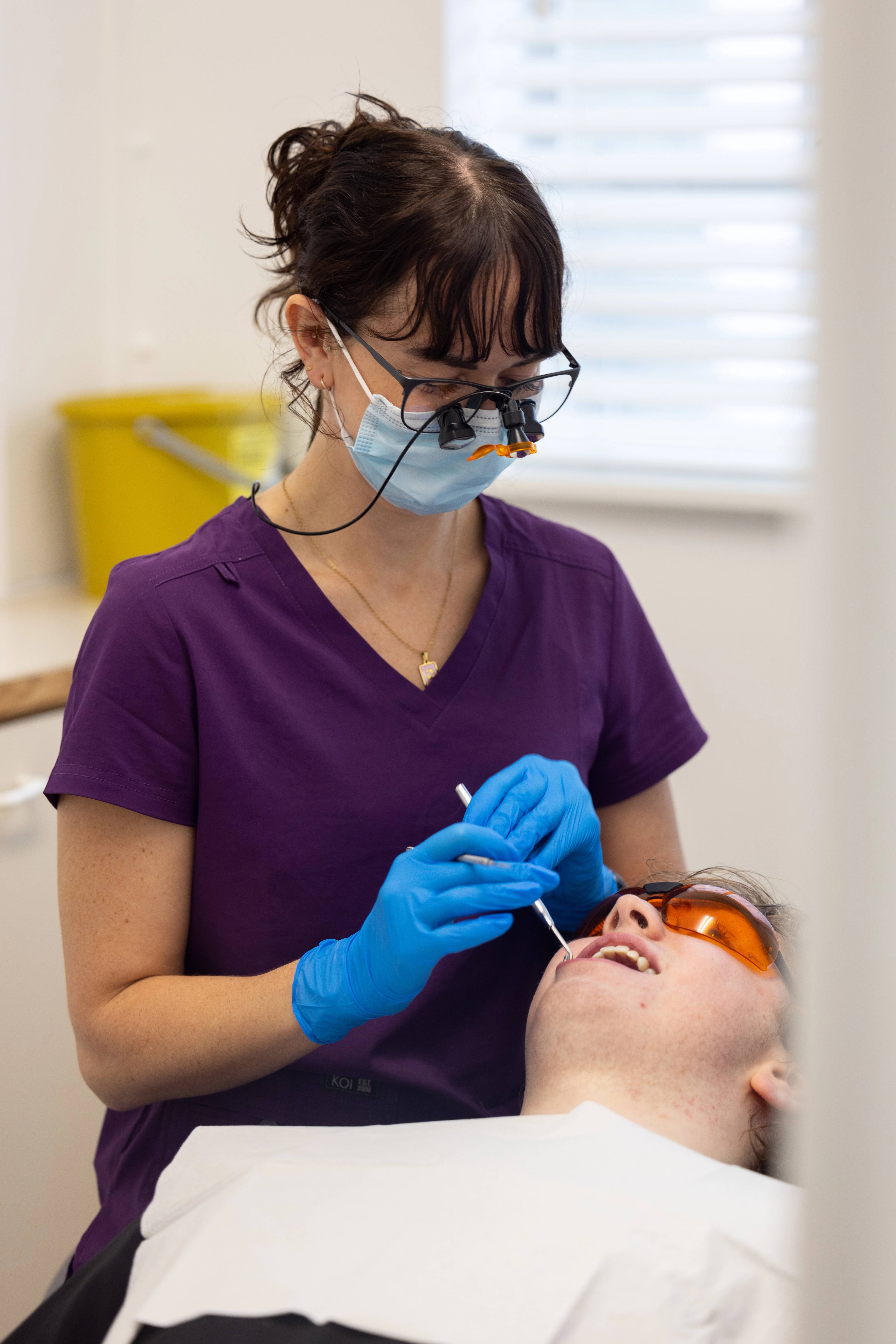 Dental therapist Lucy Steward examines a patient's teeth