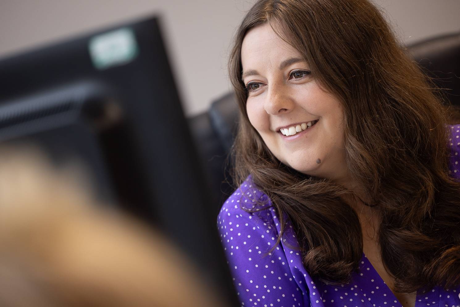 A receptionist at our practice smiles while speaking to a patient at the front desk