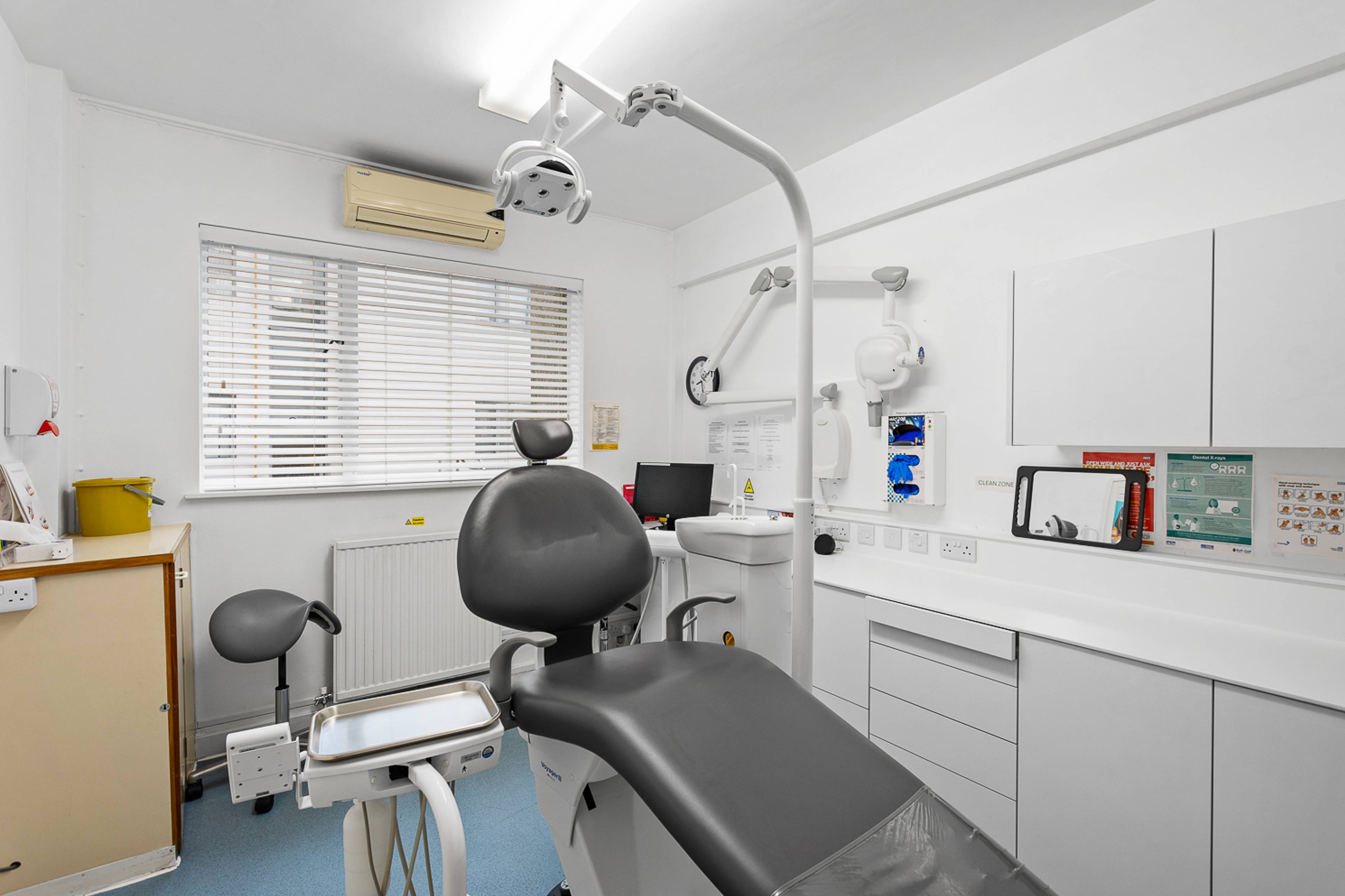 One of the bright clean treatment rooms at the clinic, with a dentists chair and other dental equipment in the room