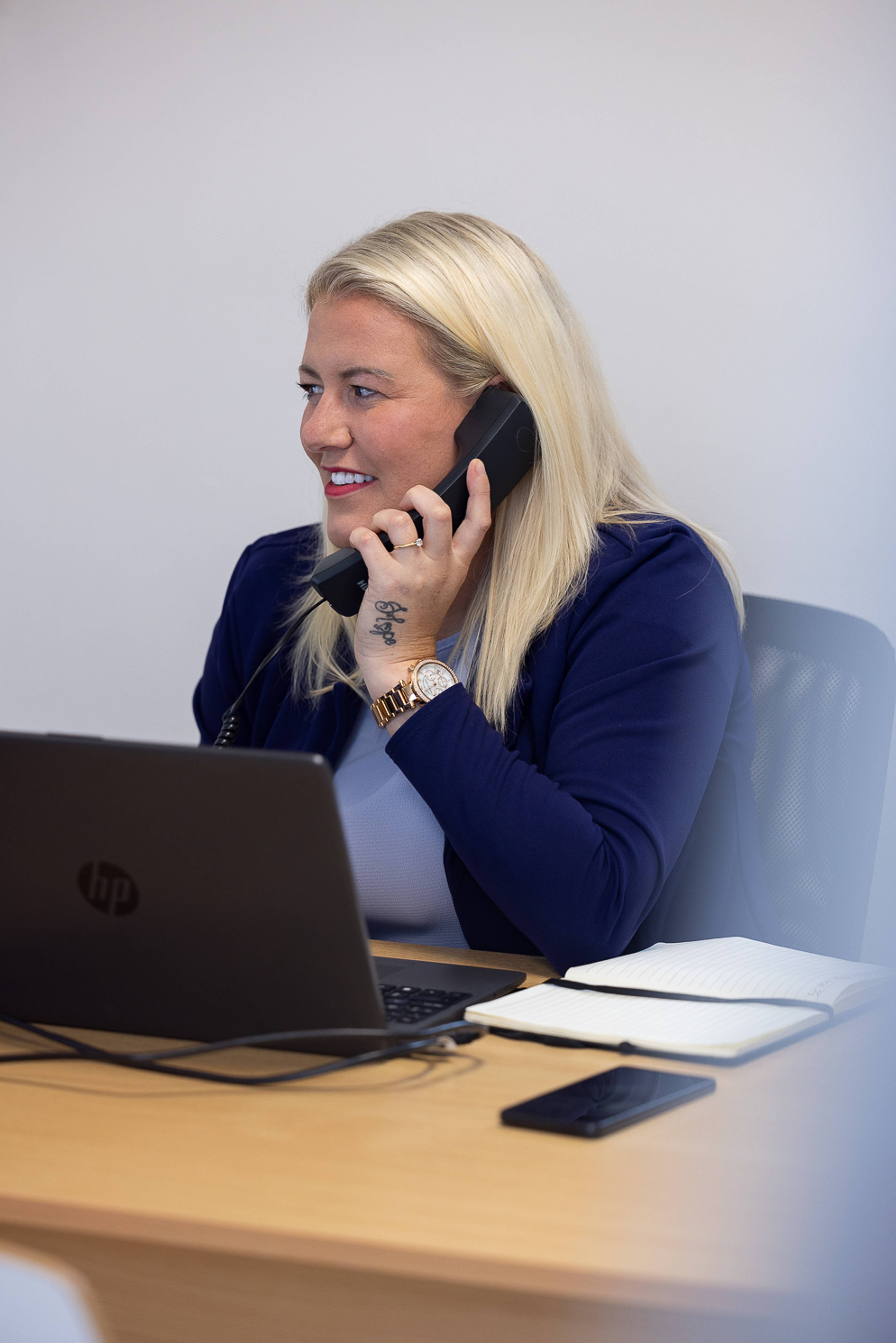 Our friendly receptionist smiling while speaking on the phone with a patient
