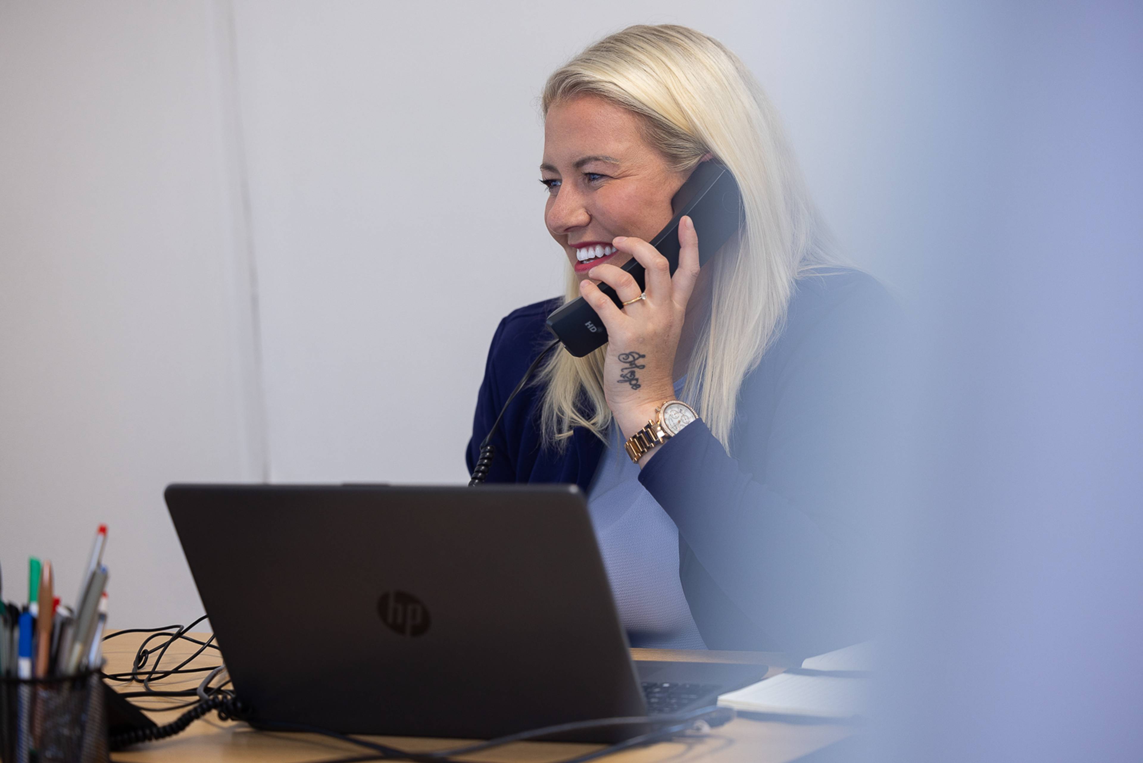 Practice manager Sophie Burrows laughing while on the phone