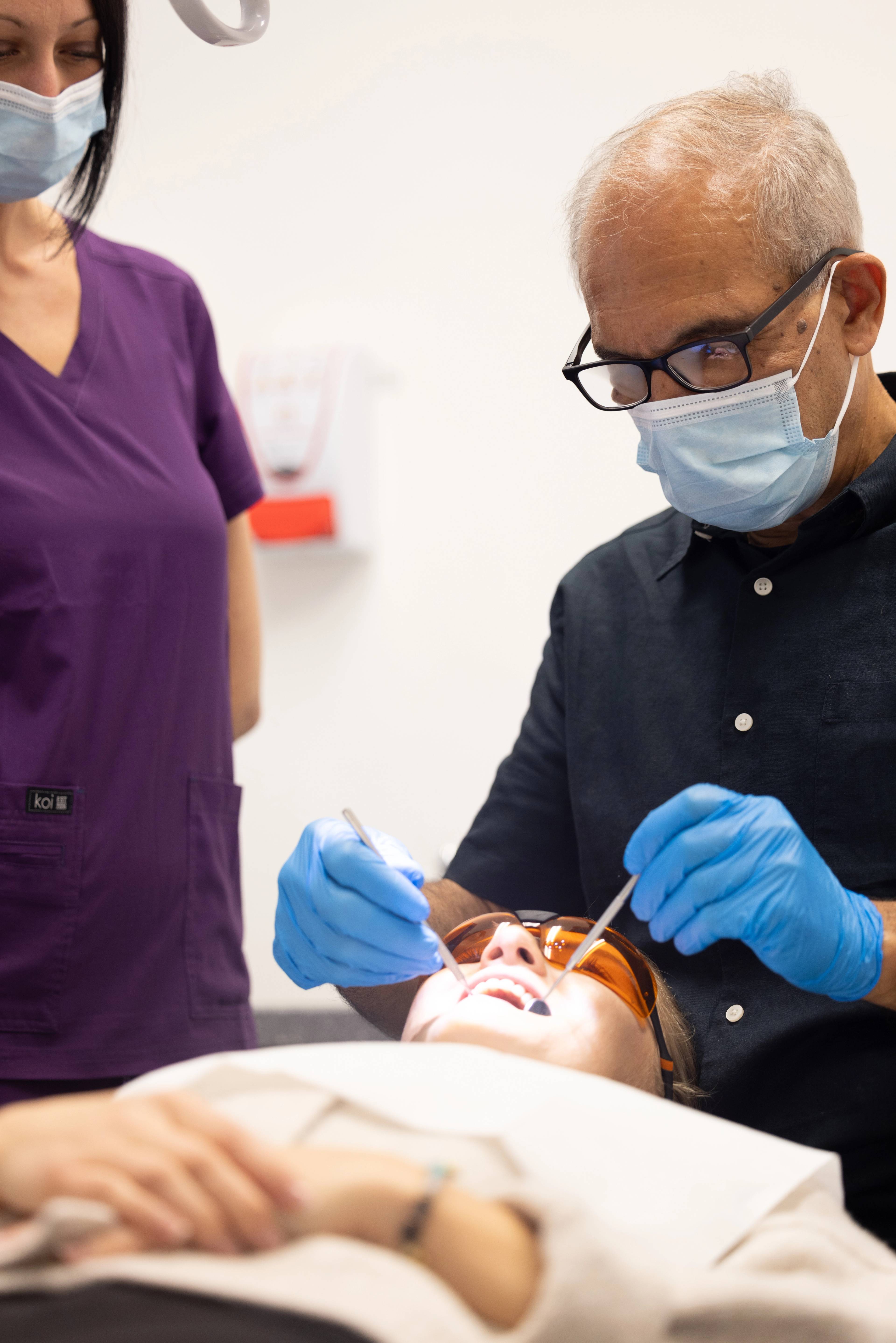 Dentist Shahriar Majlessi giving a general dental exam to a patient who is wearing eye protection