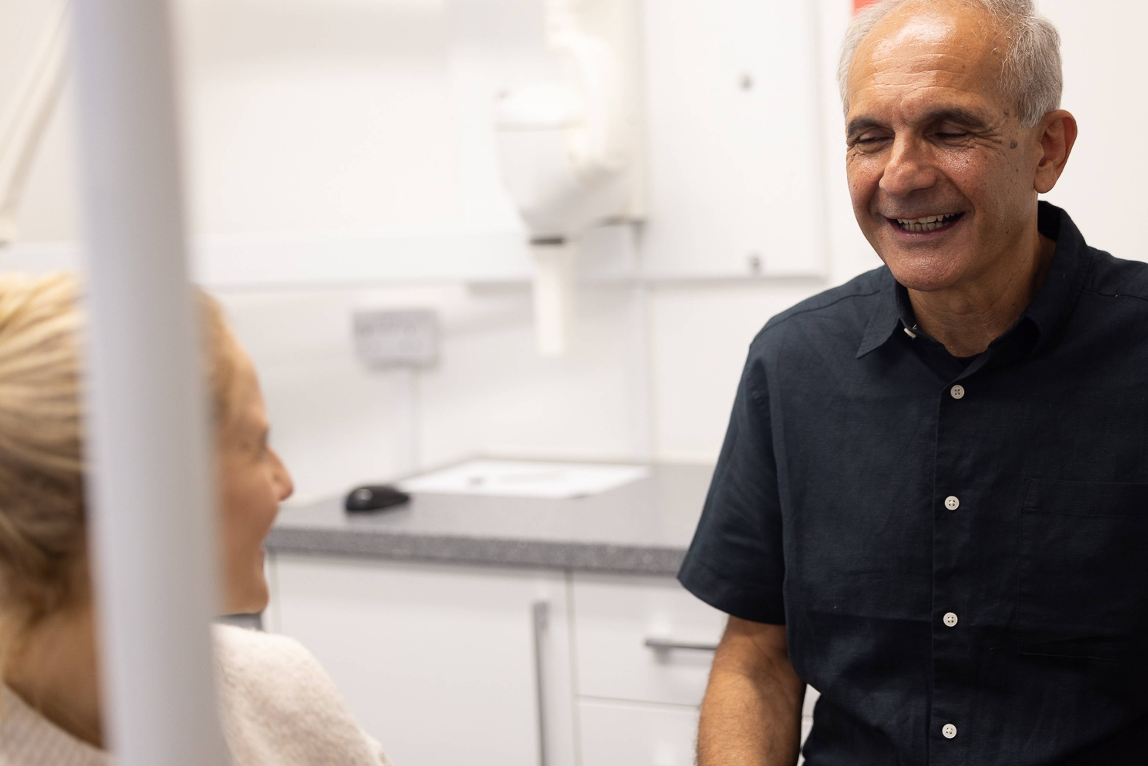Dentist Shahriar Majlessi smiles while speaking to a patient