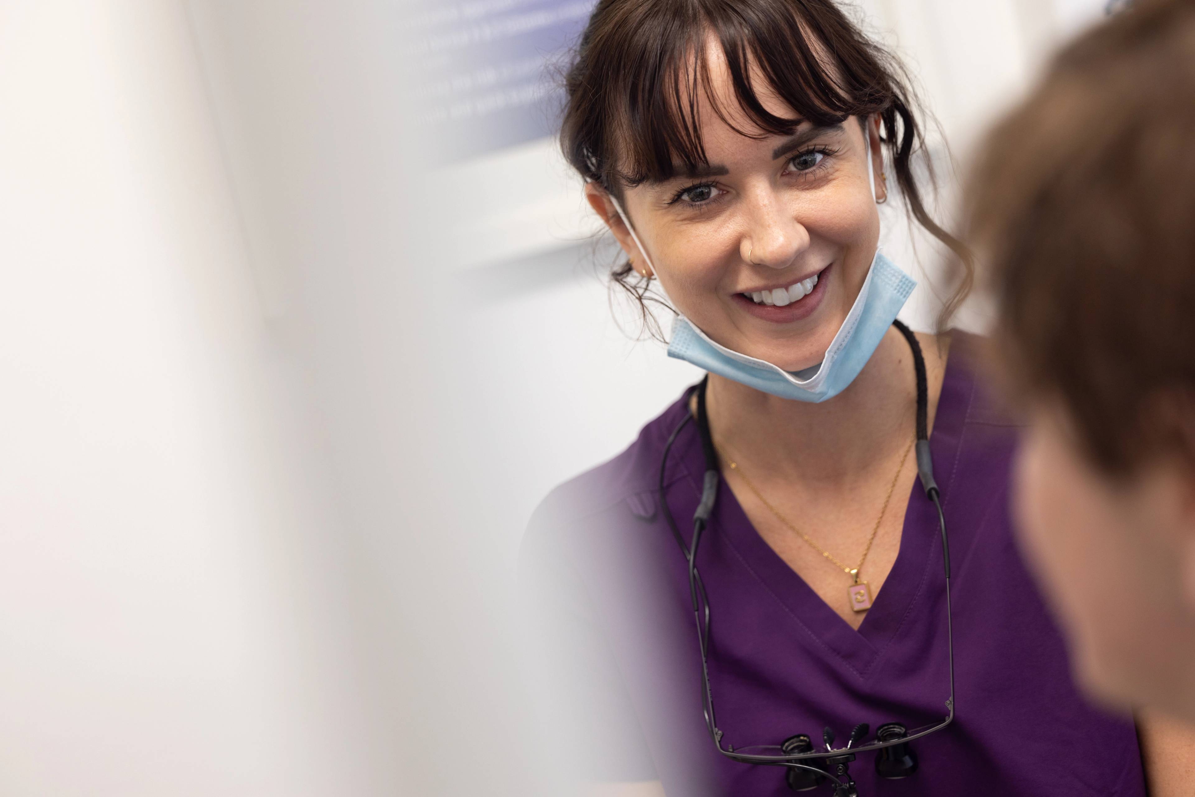 Dental Therapist Lucy Steward smiling with her face mask pulled down below her chin