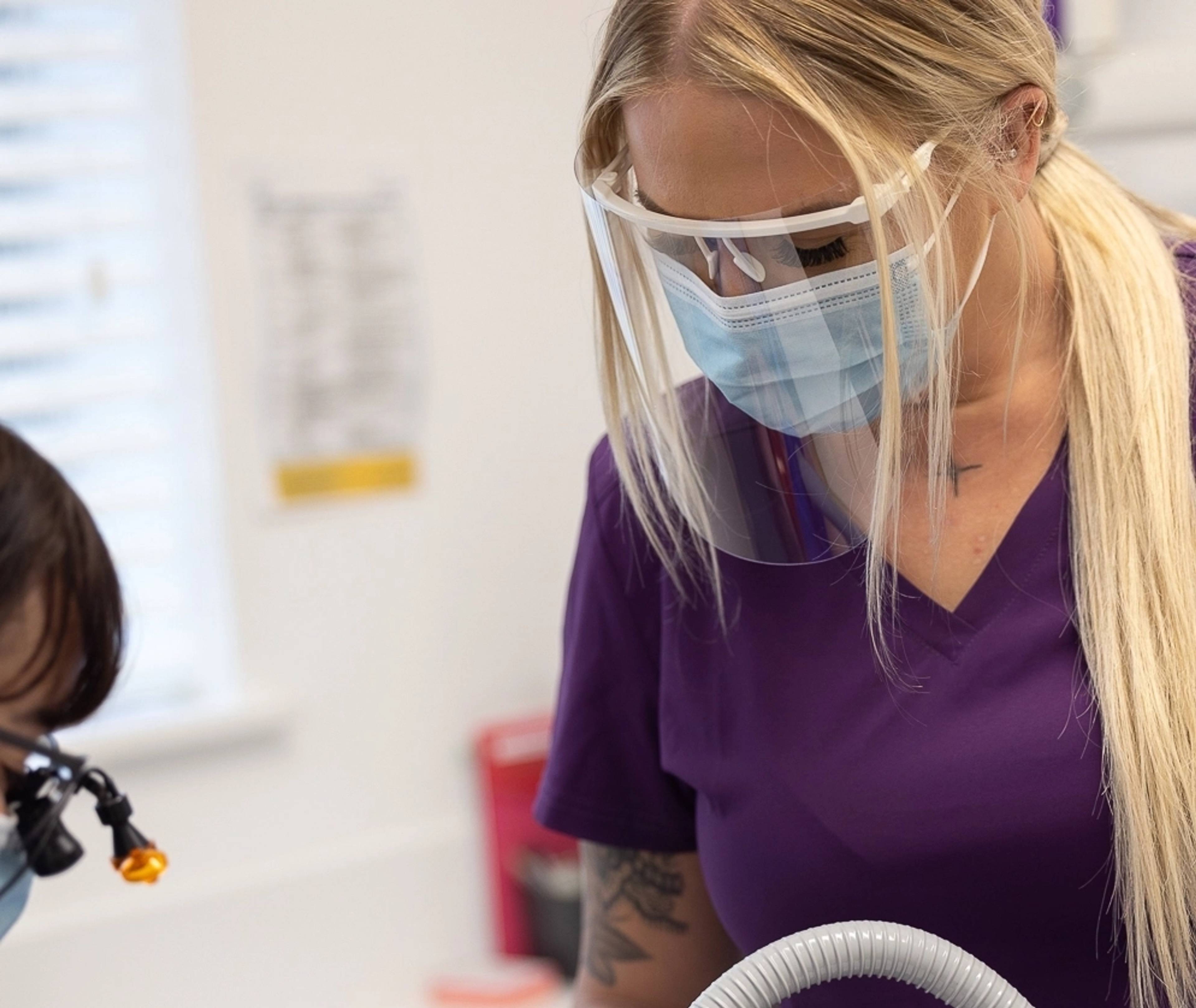 one of our dental therapists working on a patient who is out of frame