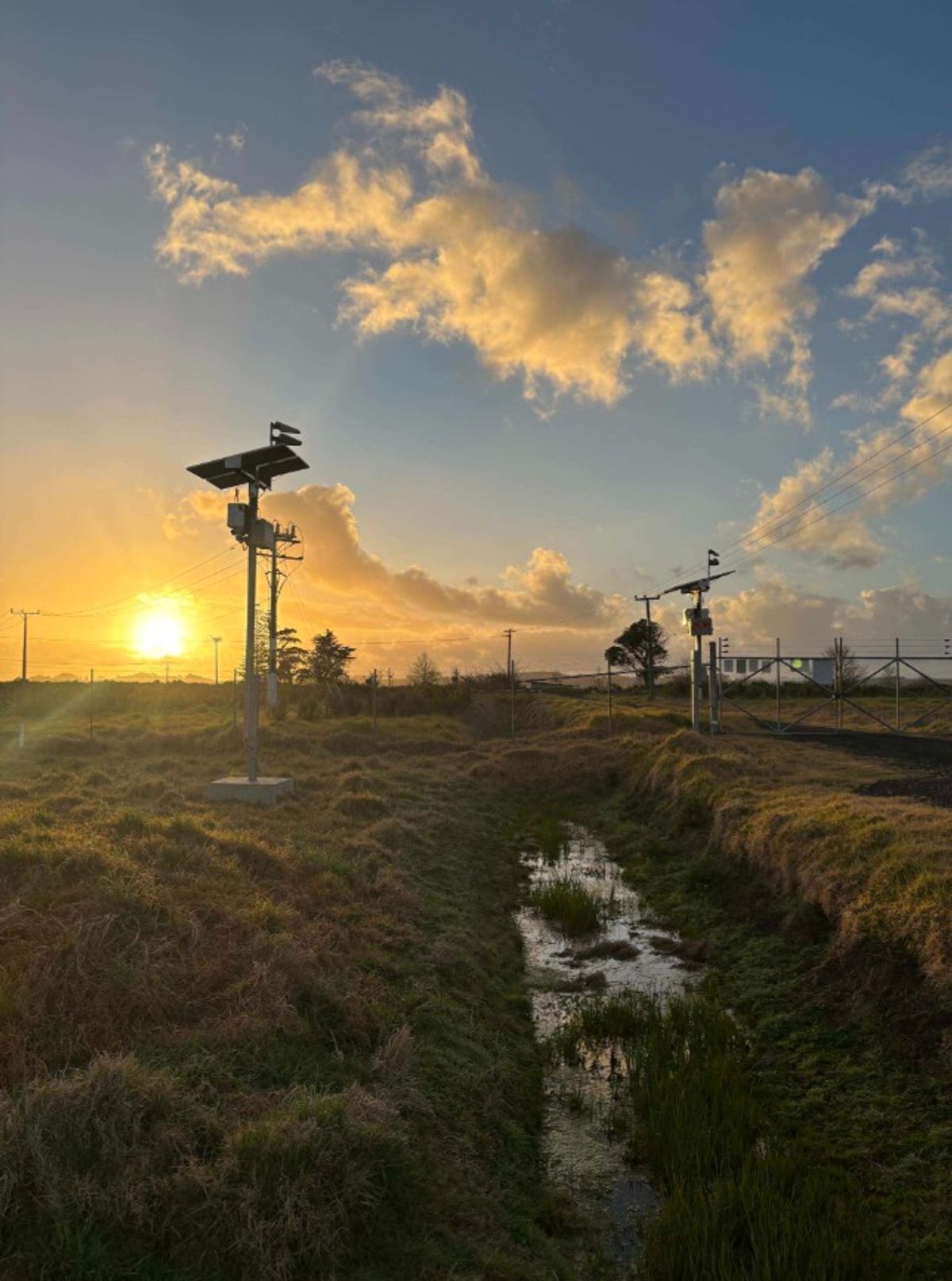 Two Crosbies solar CCTV towers in a rural paddock at sunrise