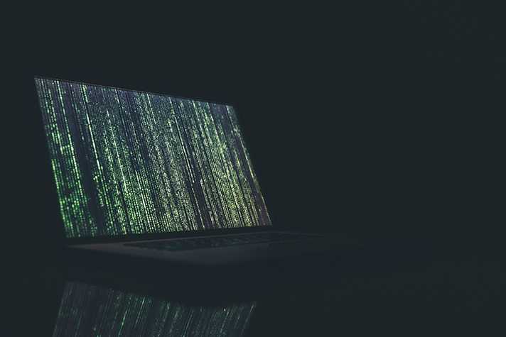 A laptop displaying computer code