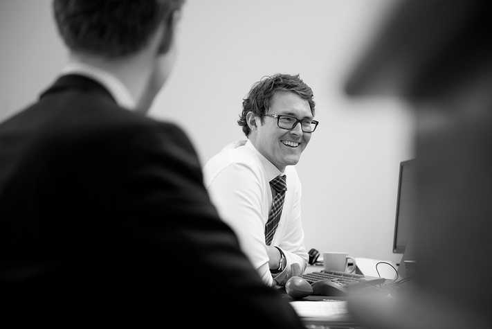 Underwriters seen in a meeting at their desks