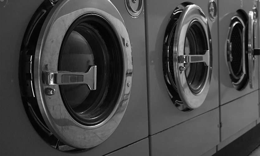 A row of tumble driers in a laundry
