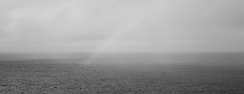 A rainbow appears above a calm sea