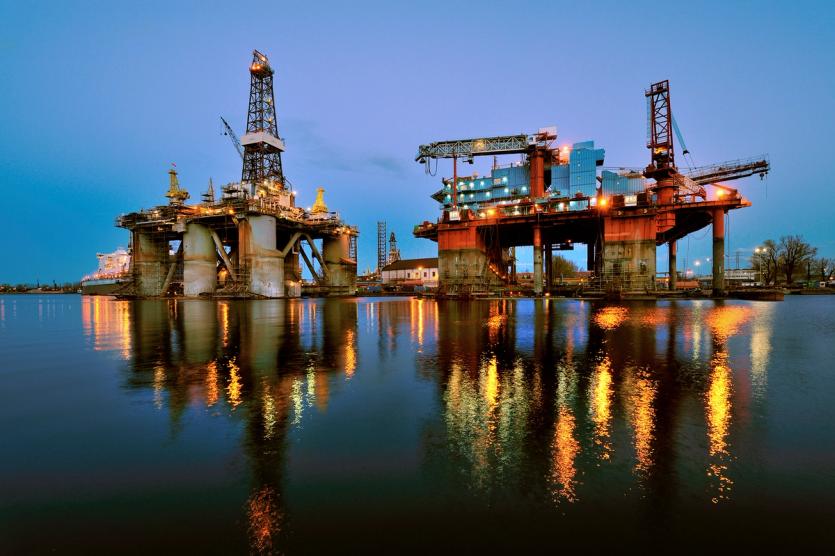Two oil rigs are seen in a yard