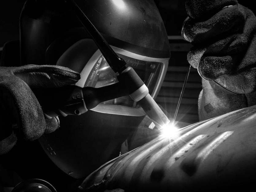 A welder works on a pipe