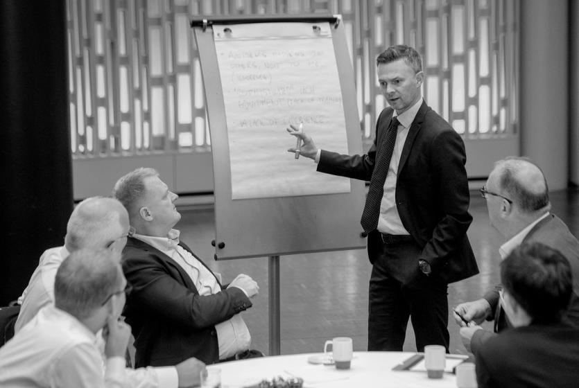 A group of people discuss topics at the Loss Prevention Committee meeting