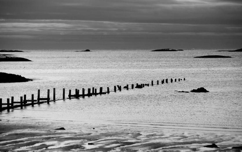Remains of an old jetty extend from the shore out into the sea