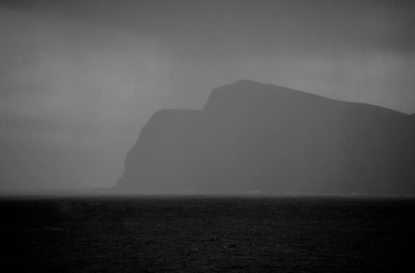 A huge mountain looms above the sea