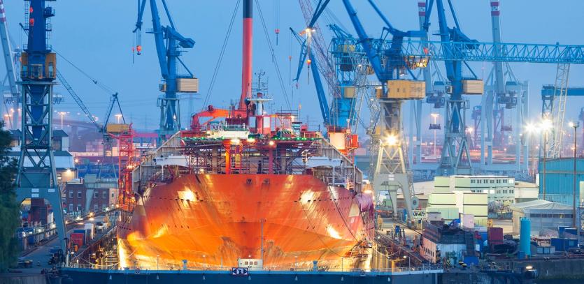 A large vessel undergoes maintenance in a shipyard
