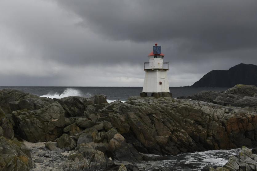 A light house on the rocky coast of Fosnavåg, Norway