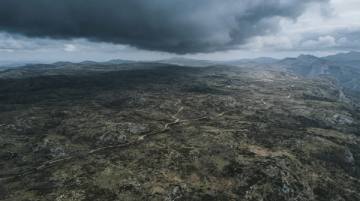 Meseta alta barrida por el viento con la sombra de un frente de nubes avanzando por encima