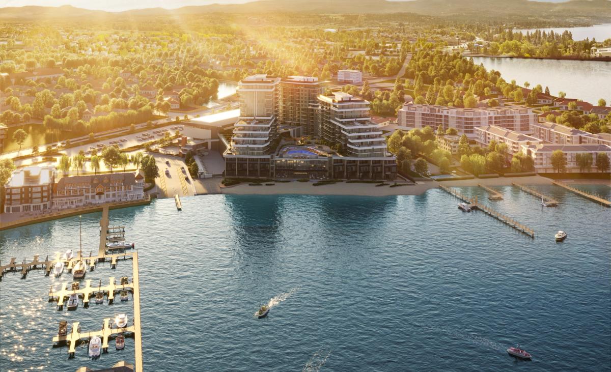 Aerial rendering of Värra Thermal's waterfront building on Okanagan Lake in Kelowna, with a marina and boats in the foreground and hills beyond.
