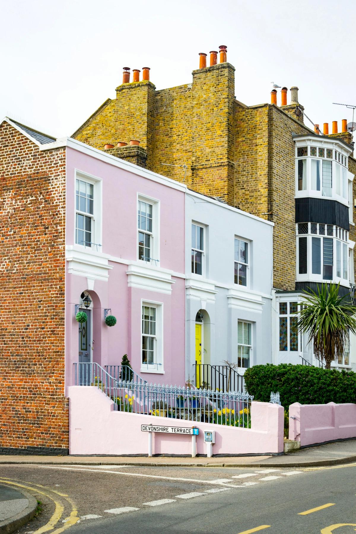 A row of pastel-coloured houses on a street corner