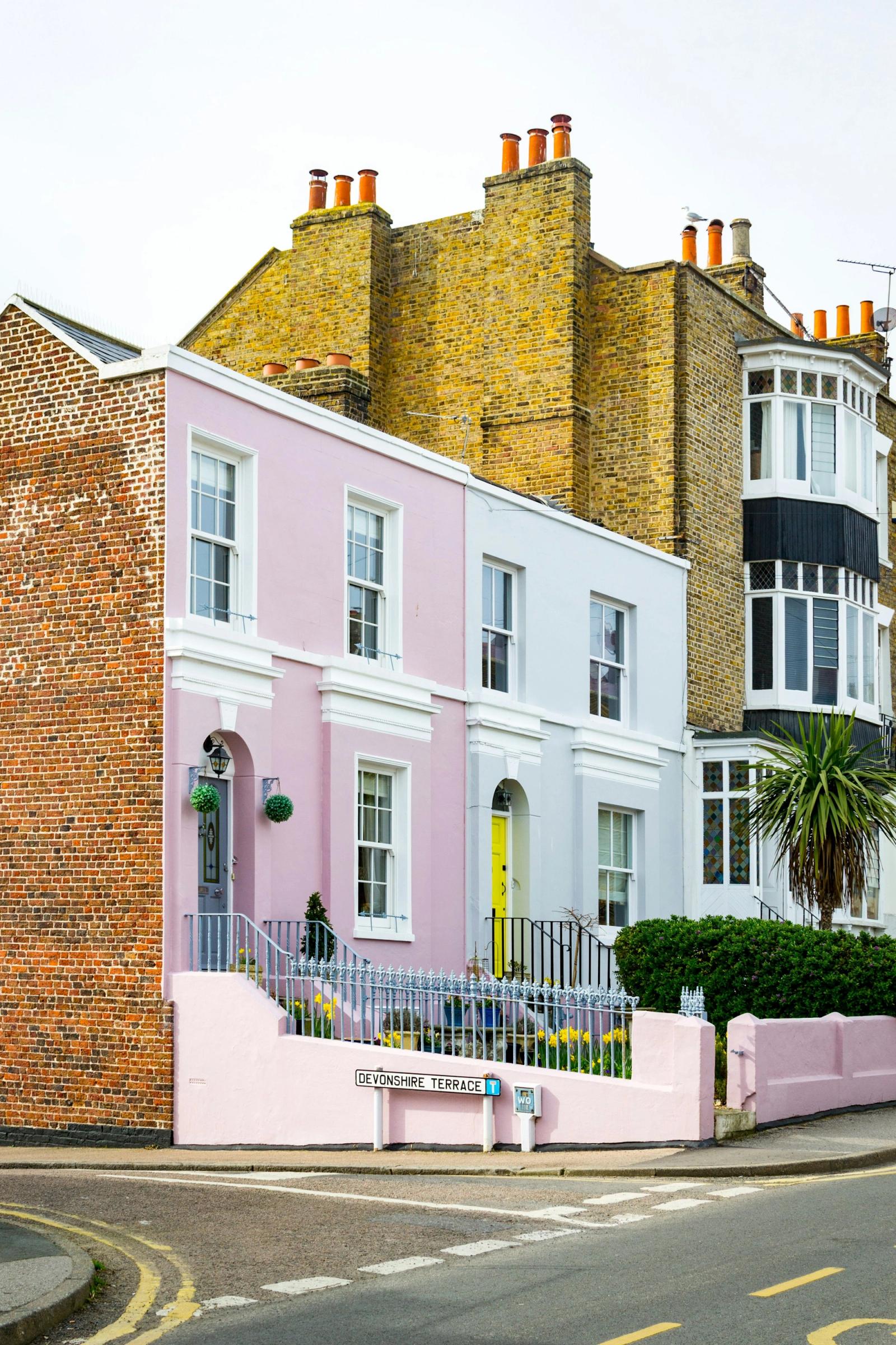 A row of pastel-coloured houses on a street corner
