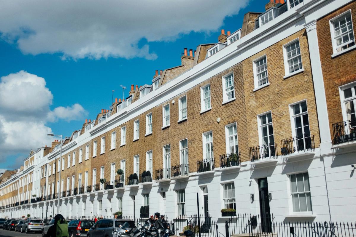 A row of terraced houses in London under a blue sky