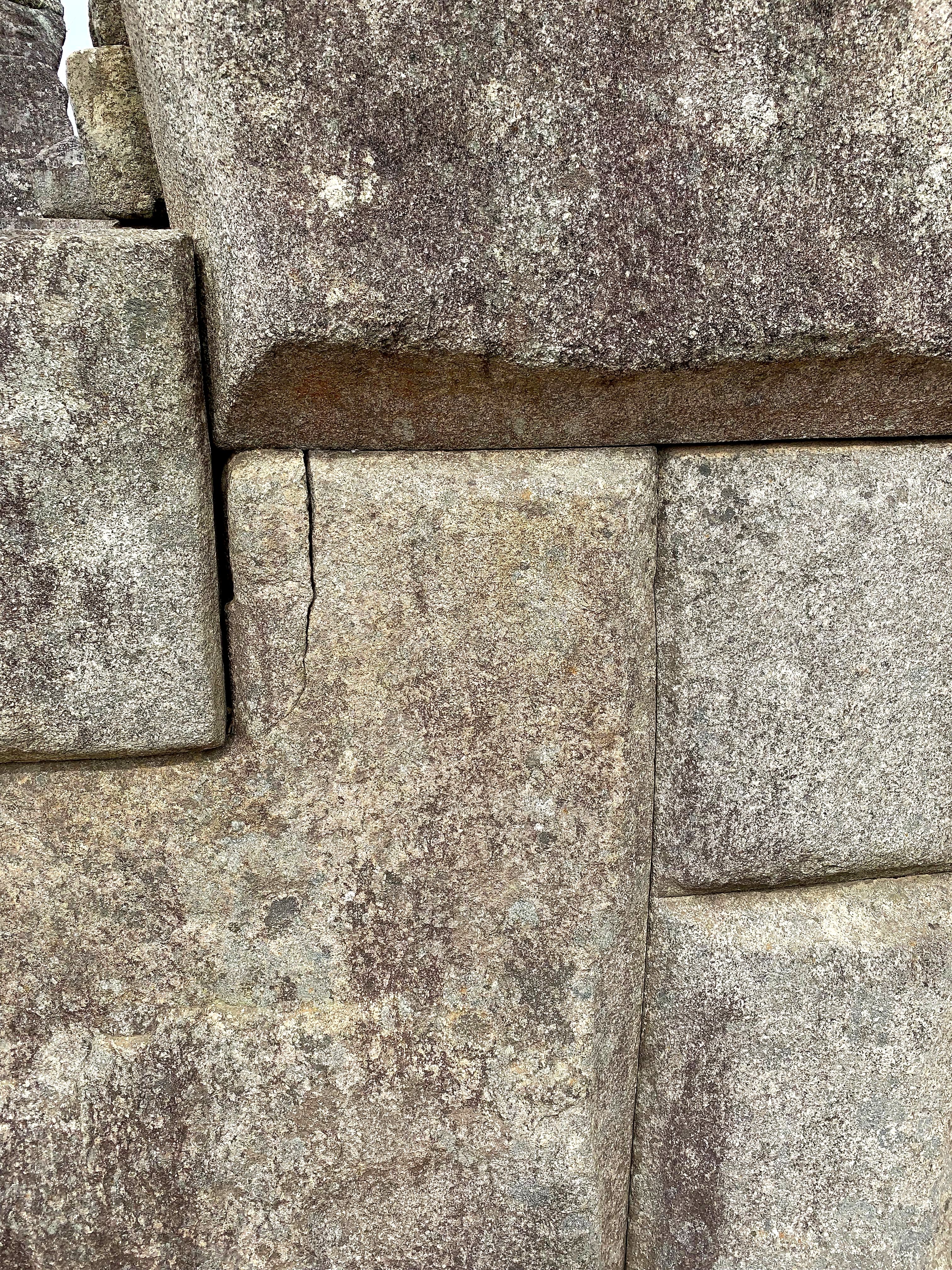 Close-up of weathered Inca stone masonry blocks fitted tightly together at Machu Picchu.