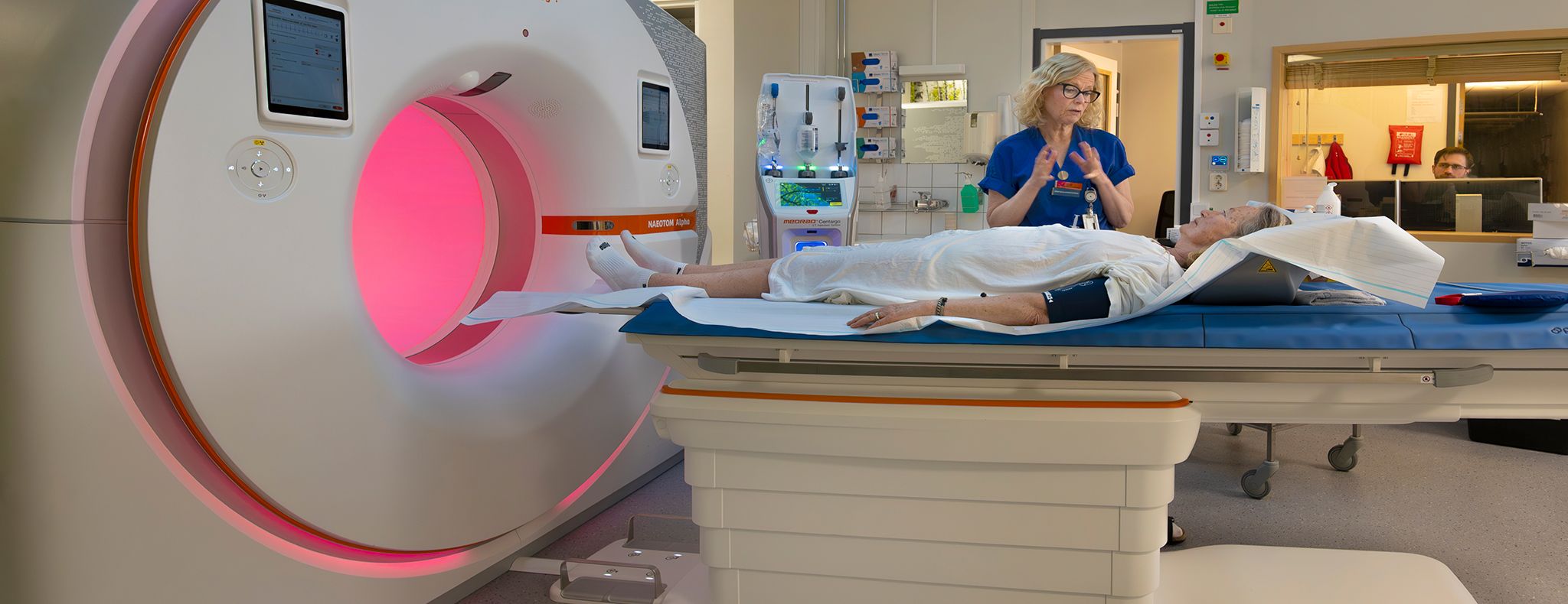 Patient being prepared for a CT scan by healthcare staff