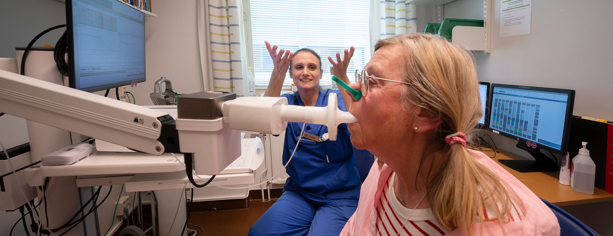 Healthcare professional performing a spirometry lung function test with a patient