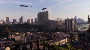 A red helicopter and a banner plane fly over the Vice City skyline, seen from a rooftop bar at sunset.