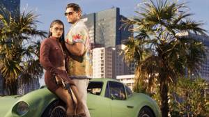 Lucia and Jason pose beside a green classic sports car, with palm trees and high-rises behind them.