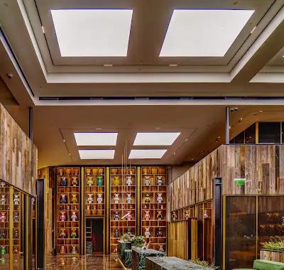 Atrio comercial terminado con muros de madera, estanterías y vegetación integrada