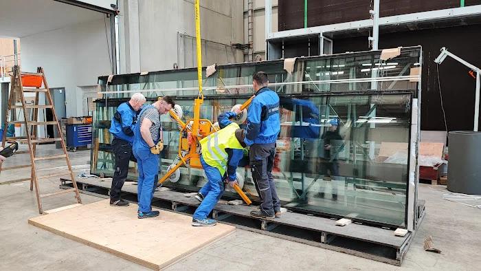 Equipo instalando grandes paneles de vidrio reflectante con andamio móvil