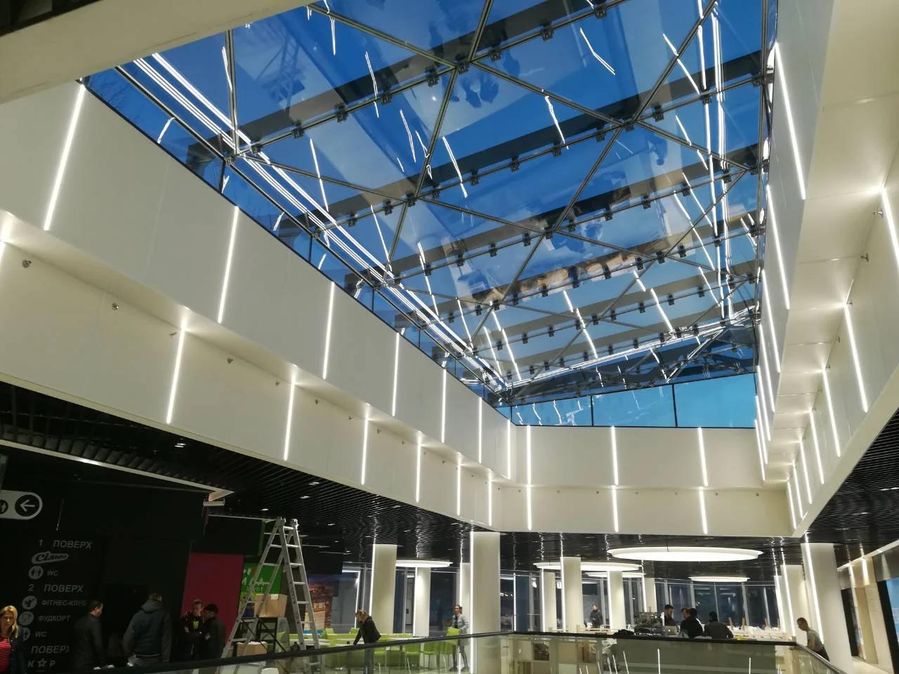 Interior comercial bajo un gran lucernario estructural de vidrio