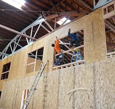 Equipo instalando entramado y elementos estructurales dentro de un edificio comercial