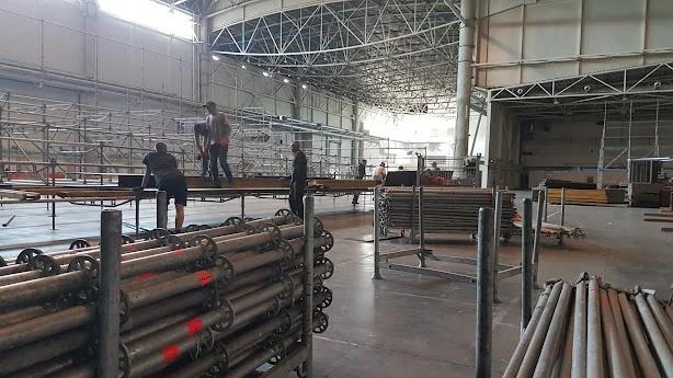 Equipo de construcción montando elementos de acero dentro de un gran edificio industrial